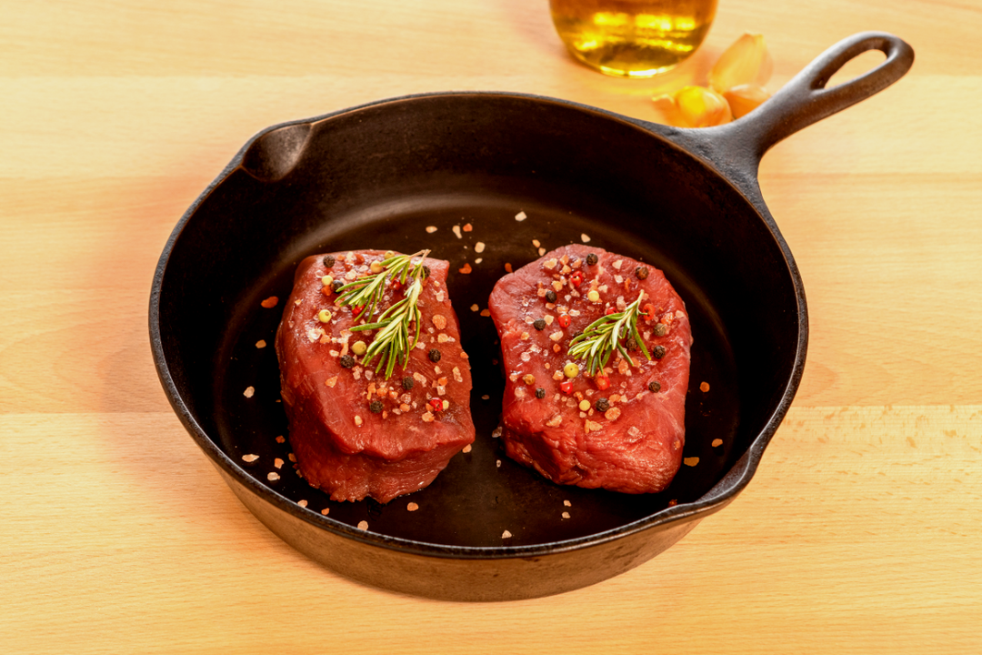 ostrich fan filets raw in a pan with seasonings 